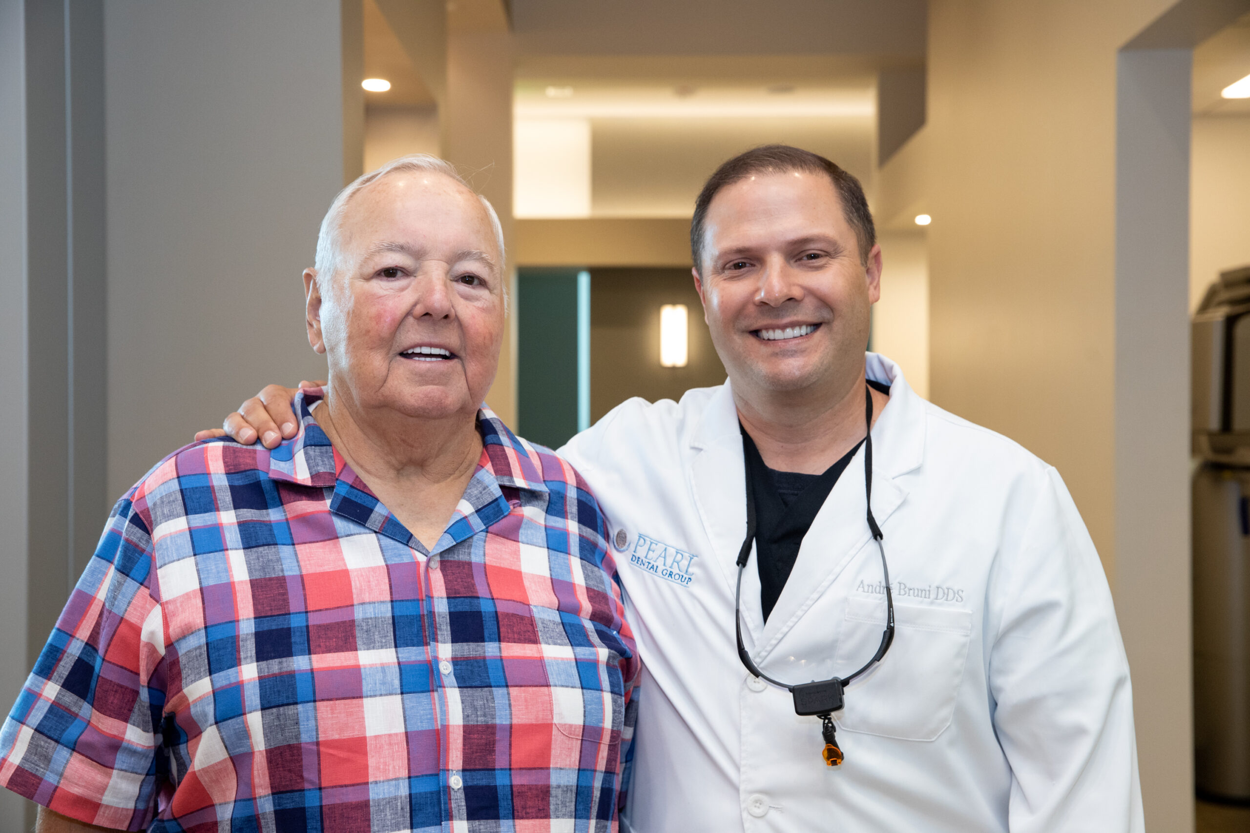 Dr. Bruni's arm over a patient who just got treated with implant supported dentures. Fixed vs Removable Teeth